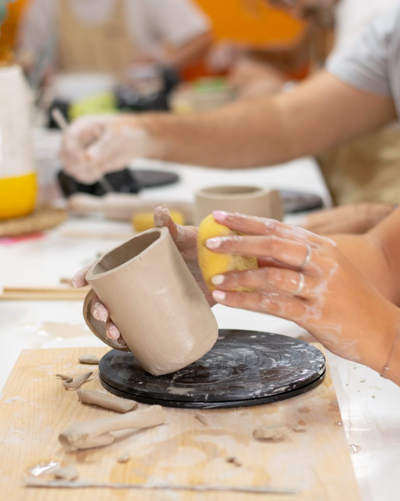 Alumno modelando su taza en barro en el taller de cerámica málaga